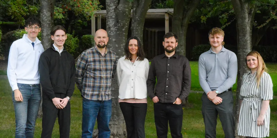 The Newton & Co team in front of the trees outside the office